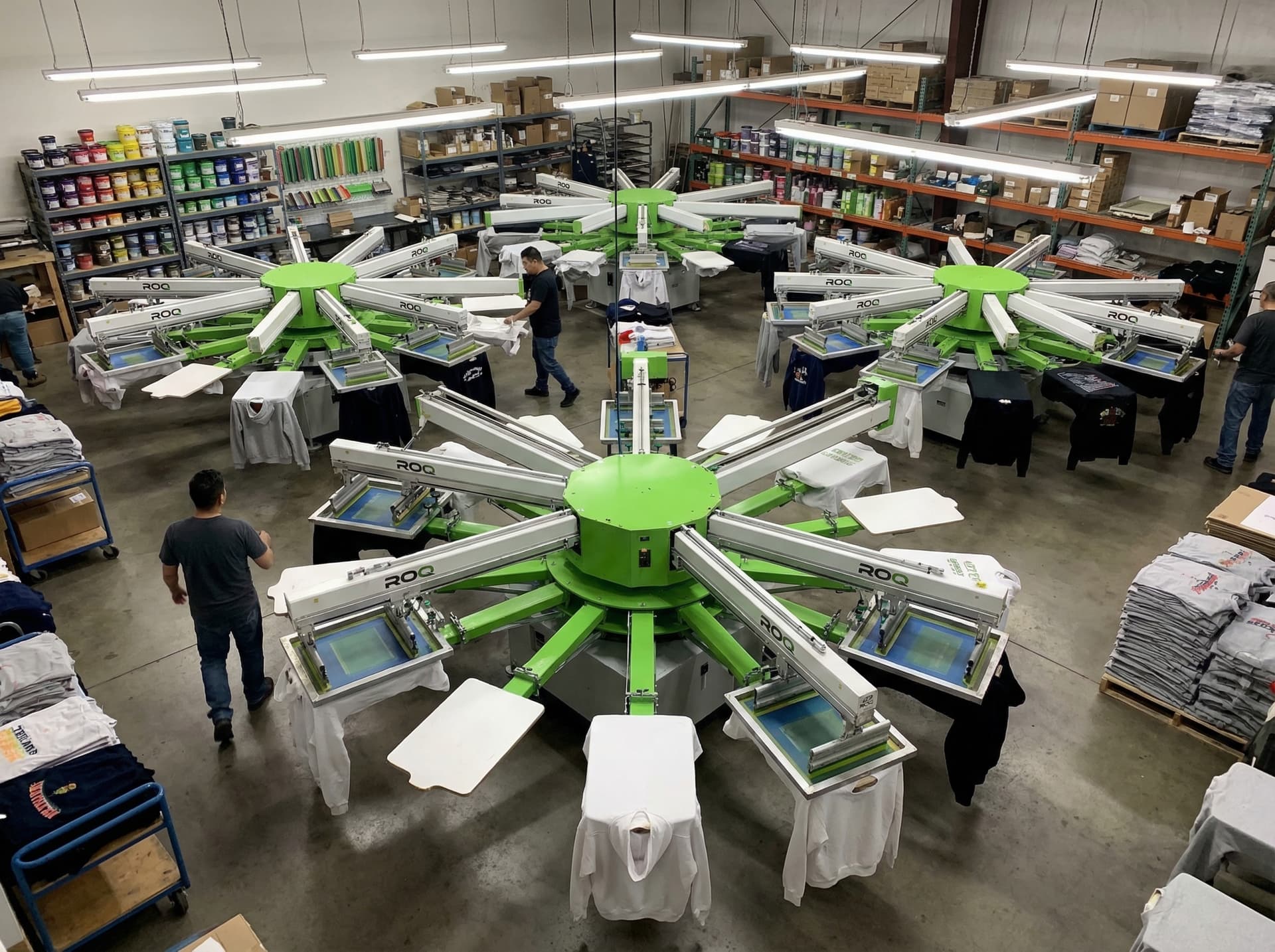 ROQ automatic rotary screen printing press with neon green ink printing on black t-shirts